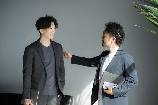 育休を取るか悩みながらも、上司へ育休を取ることを報告しようとする男性とその上司の様子