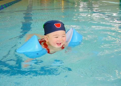 育休中のパパに連れられてベビースイミングをしている生後7ヶ月の赤ちゃん